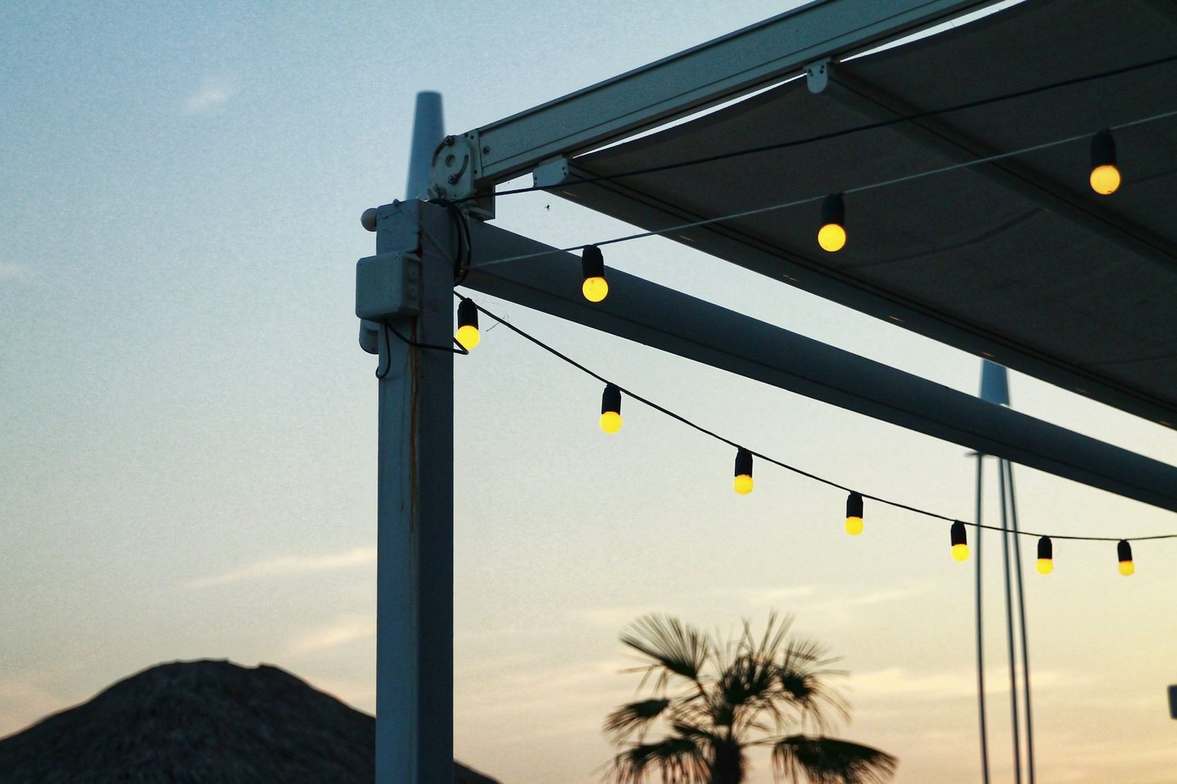 Covered patio strung with lights at dusk